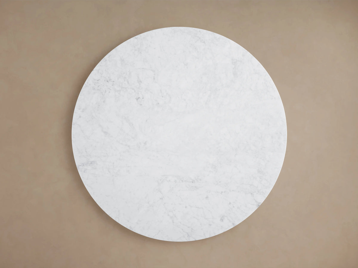 Round white Carrara marble top of Danny Coffee Table, featuring natural veining patterns, viewed from above.