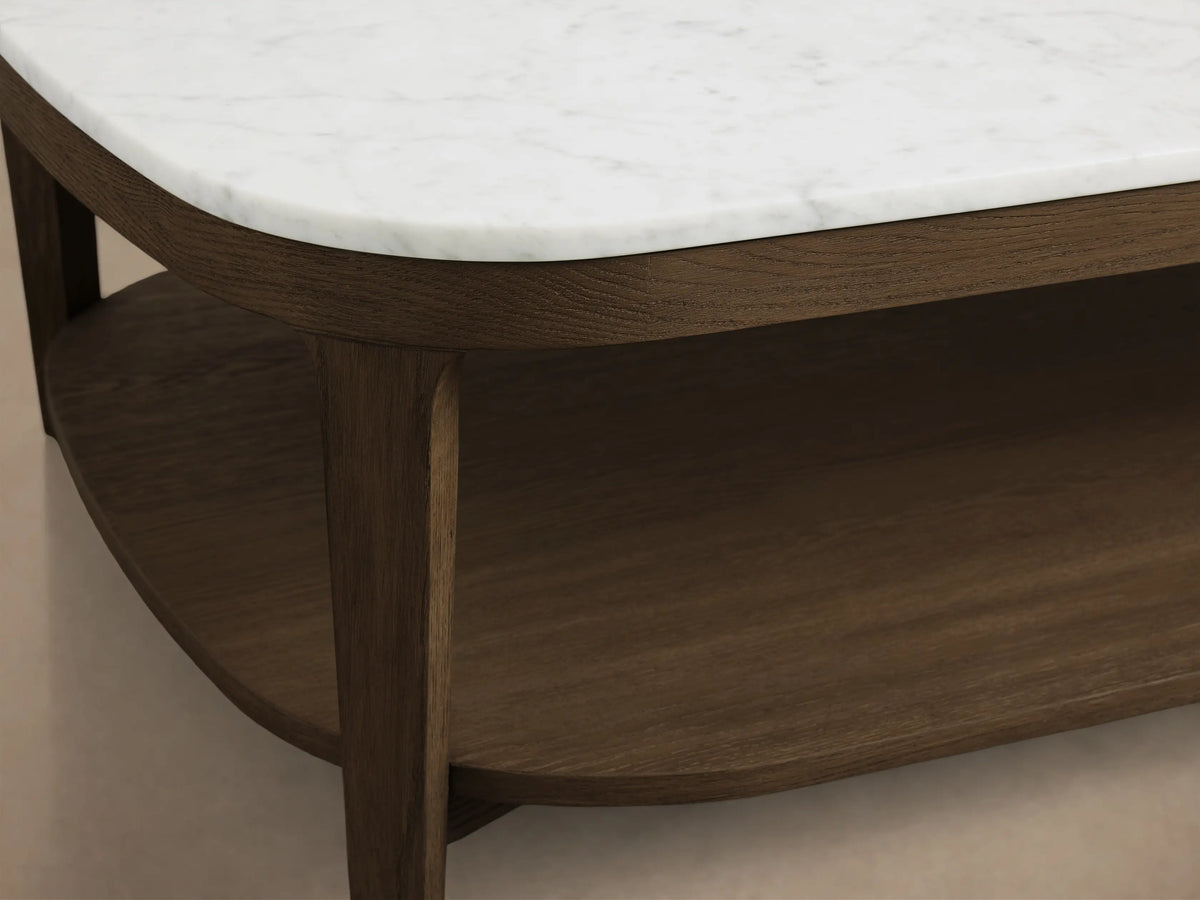Front view of Oval Marble Top Coffee Table, with a white marble top and dark brown wooden frame including a lower shelf.