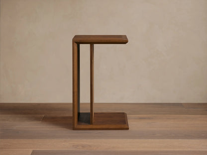 Elien C Table in a rich brown wood finish on a wooden floor, featuring a minimalist C-shape design.