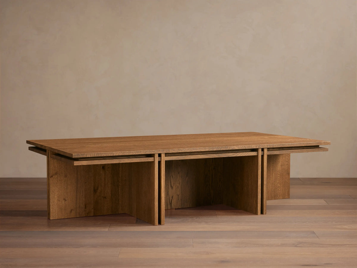 Eaves Coffee Table: Modern rectangular solid oak wood with double-frame design, warm brown finish, on a wood floor.