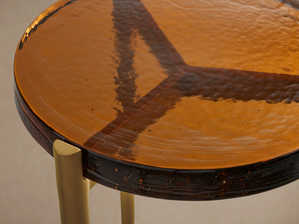 Ezio Martini Table with an amber cast glass top, featuring a unique bubble effect and uneven texture, on gold iron legs.