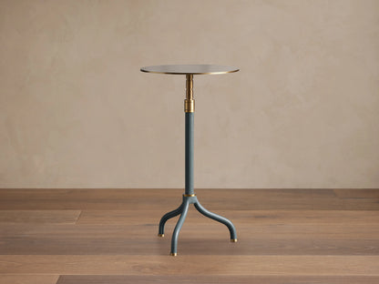 Ferdinand Leather Martini Table with blue leather-wrapped stem, brass accents, and a brass-finished tabletop on a wooden floor.