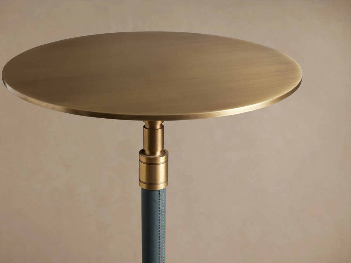 Ferdinand Leather Martini Table with blue leather-wrapped stem, brass accents, and a brass-finished tabletop on a wooden floor.