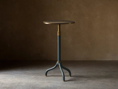 Ferdinand Leather Martini Table with blue leather-wrapped stem, brass accents, and a brass-finished tabletop on a wooden floor.