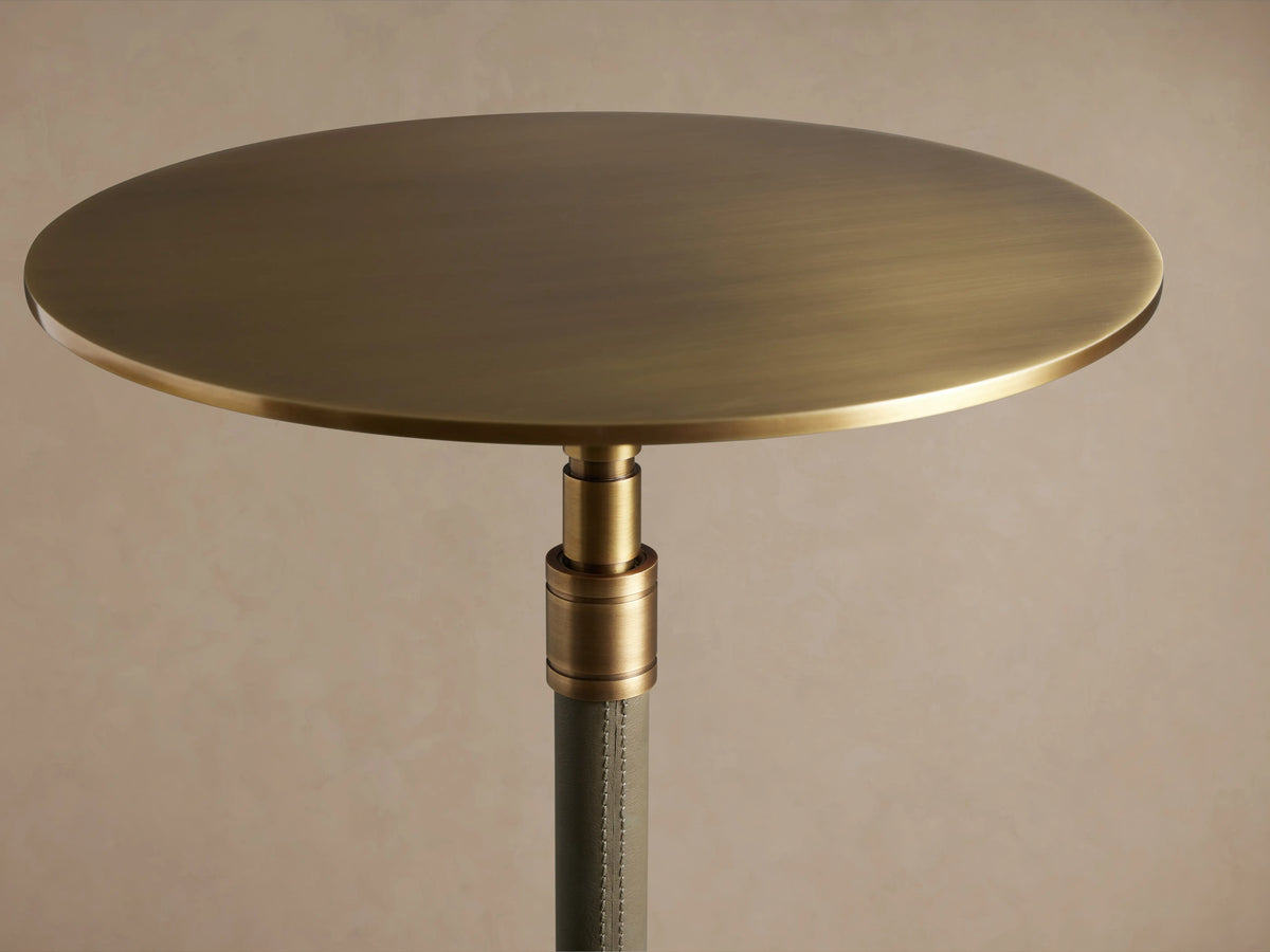 Ferdinand Leather Martini Table with a round, brass-finished tabletop on a sturdy stand, wrapped in rich-colored leather.