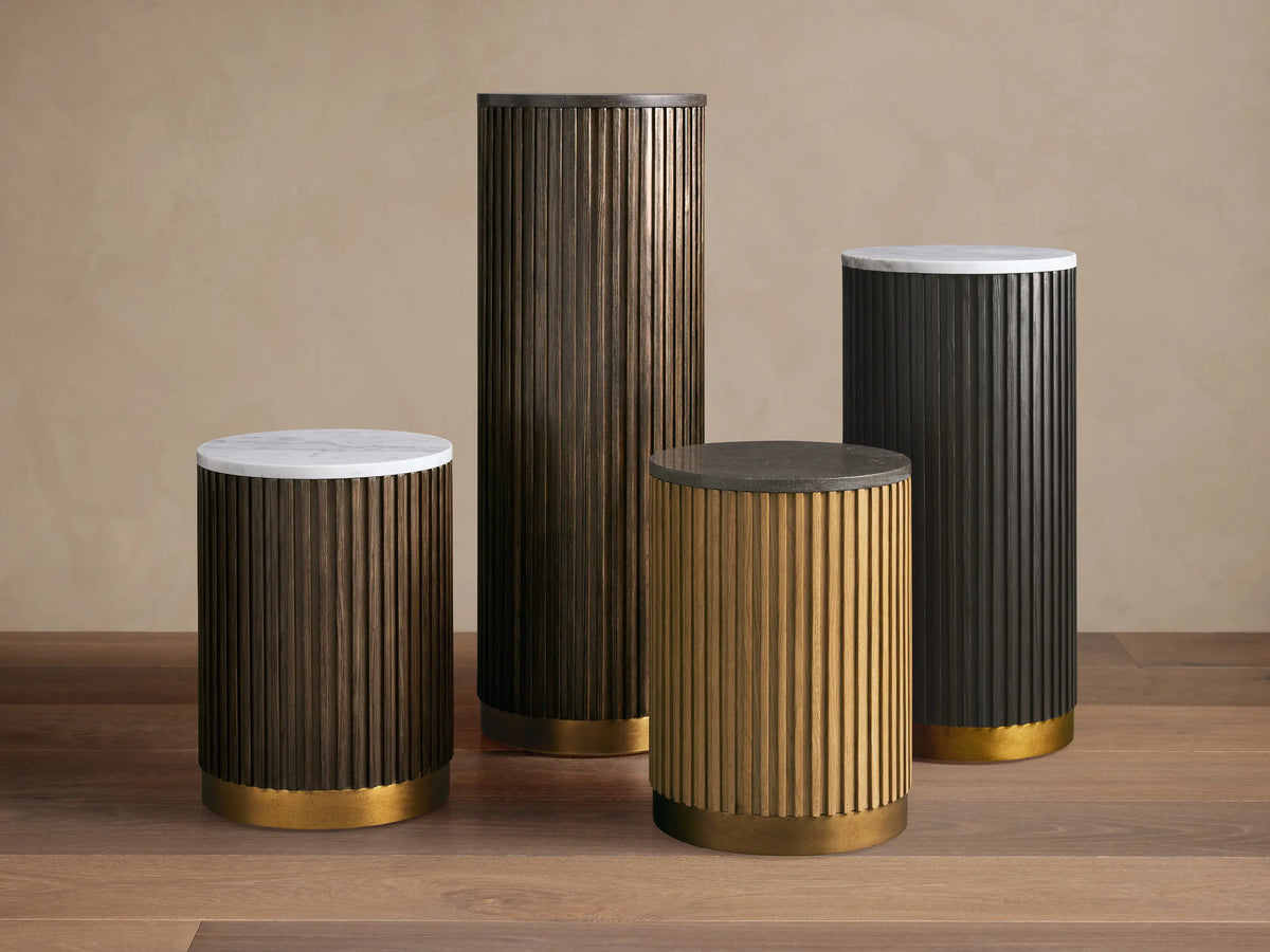Circular Finnley Pedestal with a dark stone-like top and ribbed wooden base in a rich brown finish, set against a neutral background.
