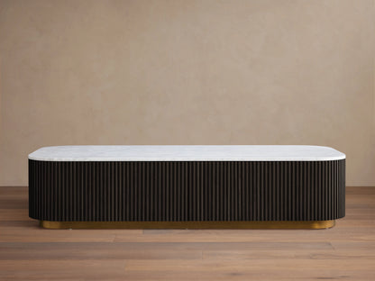 Finnley Storage Coffee Table with a white top and dark ribbed sides on a brass-finished base, on a wooden floor.