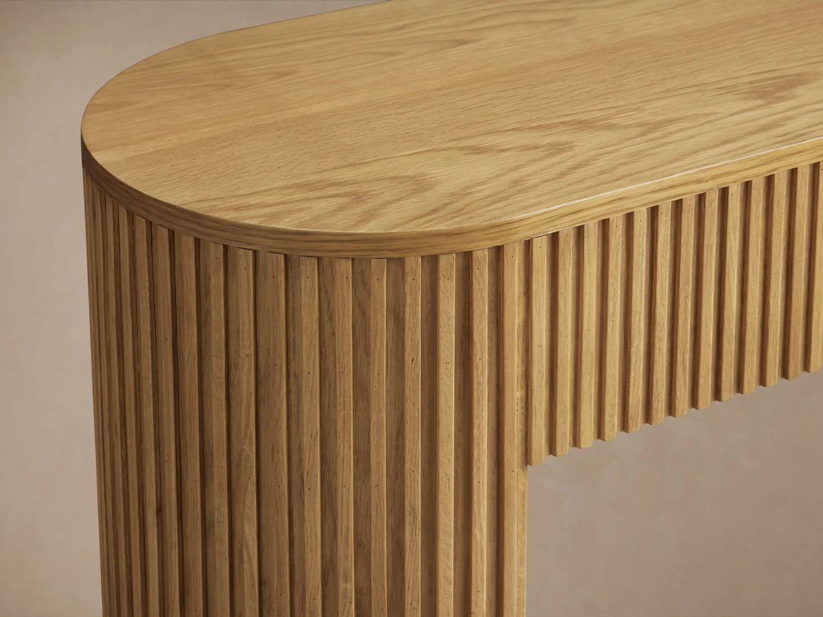 Finnley Wood Console Table in Honey finish, made of white oak with oak veneers, features vertical grooves and rounded edges.