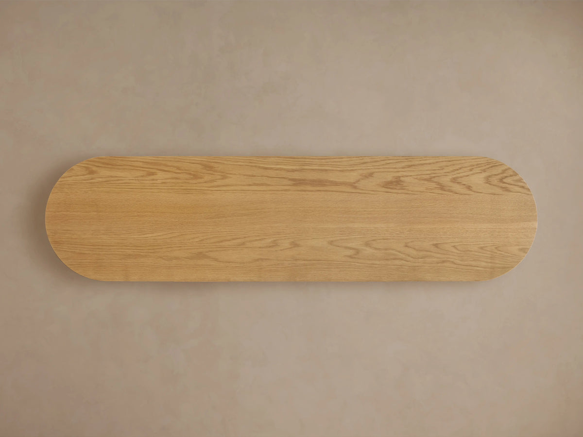 Finnley Wood Console Table in Honey finish, showing rounded edge with vertical grooves, highlighting oak grain and lacquer sheen.