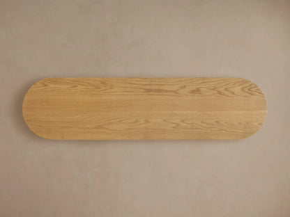 Finnley Wood Console Table in Honey finish, showing rounded edge with vertical grooves, highlighting oak grain and lacquer sheen.