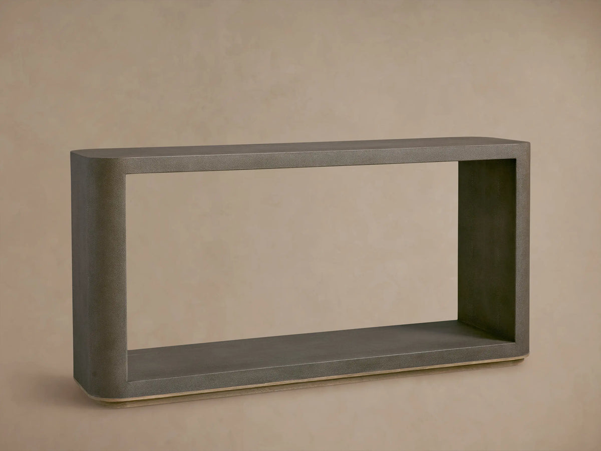 Harrow Console Table with gray faux shagreen texture, rectangular shape, wooden base. Holds books and dark bowls on top, candle and dish below.