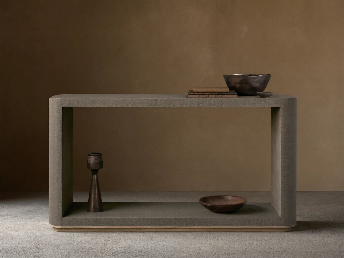 Harrow Console Table with gray faux shagreen texture, rectangular shape, wooden base. Holds books and dark bowls on top, candle and dish below.