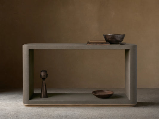 Harrow Console Table with gray faux shagreen texture, rectangular shape, wooden base. Holds books and dark bowls on top, candle and dish below.