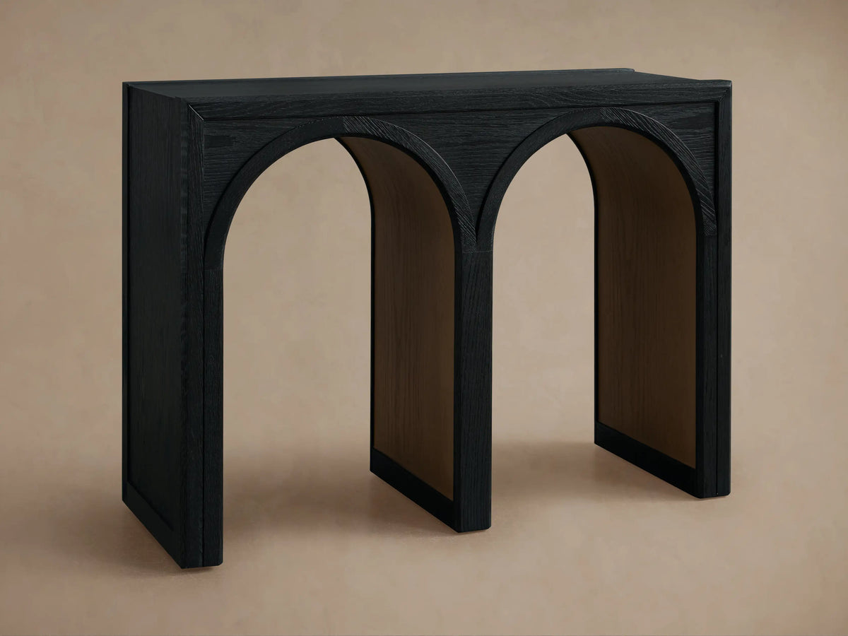 Hattie Console Table made from dark oak wood with three arch designs and contrasting interior finish. Small bowl on top.
