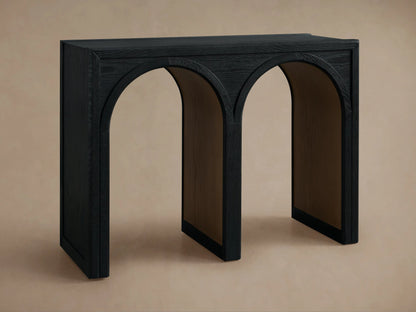 Hattie Console Table made from dark oak wood with three arch designs and contrasting interior finish. Small bowl on top.