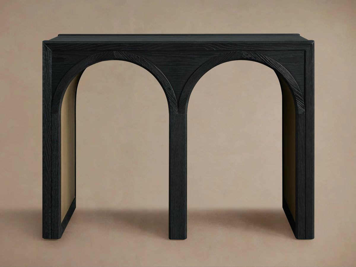 Hattie Console Table in black oak with curved arch details, showing contrasting light wood interiors on a neutral background.
