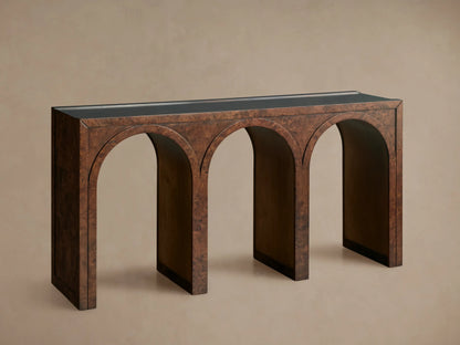 Hattie Burl Console Table: brown burl wood with three arches, dark top, neutral bowl & small decor items on top, against a beige wall.