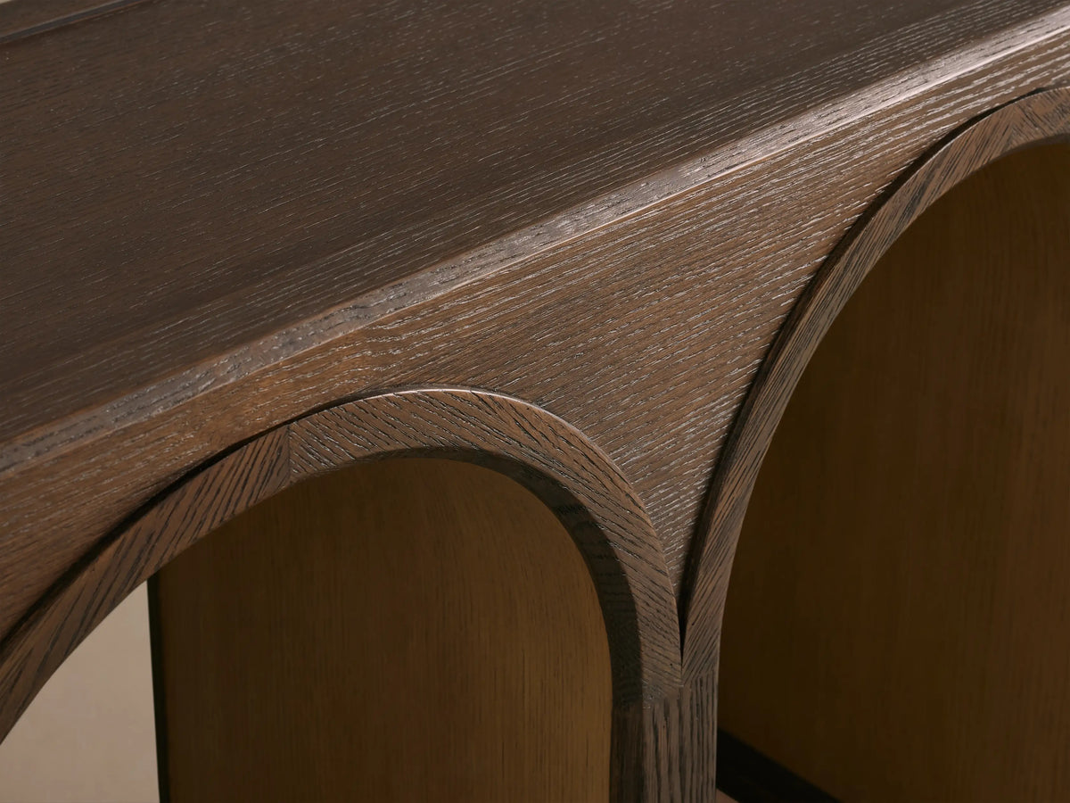Dark oak Hattie Console Table with three arched legs. Arches have contrasting lighter interiors, showcasing wood grain.