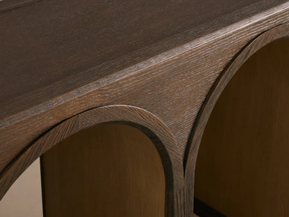Dark oak Hattie Console Table with three arched legs. Arches have contrasting lighter interiors, showcasing wood grain.