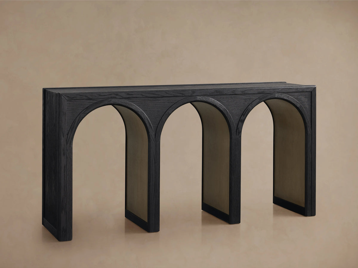 Hattie Console Table with solid oak construction, dark finish, and three arched legs with contrasting interiors, on a beige background.