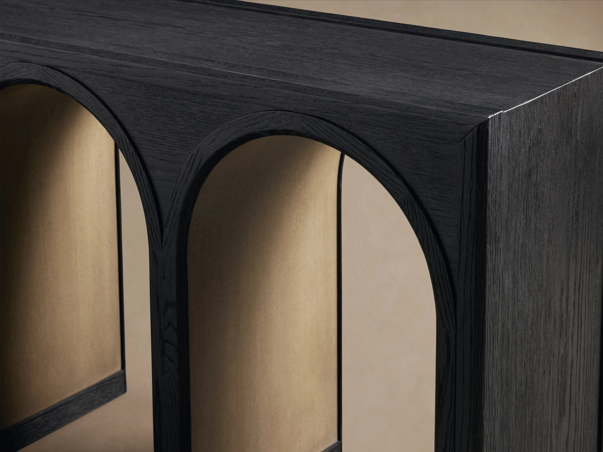 Hattie Console Table made from solid oak with five arch-shaped legs and a dark finish, on a wooden floor against a beige wall.