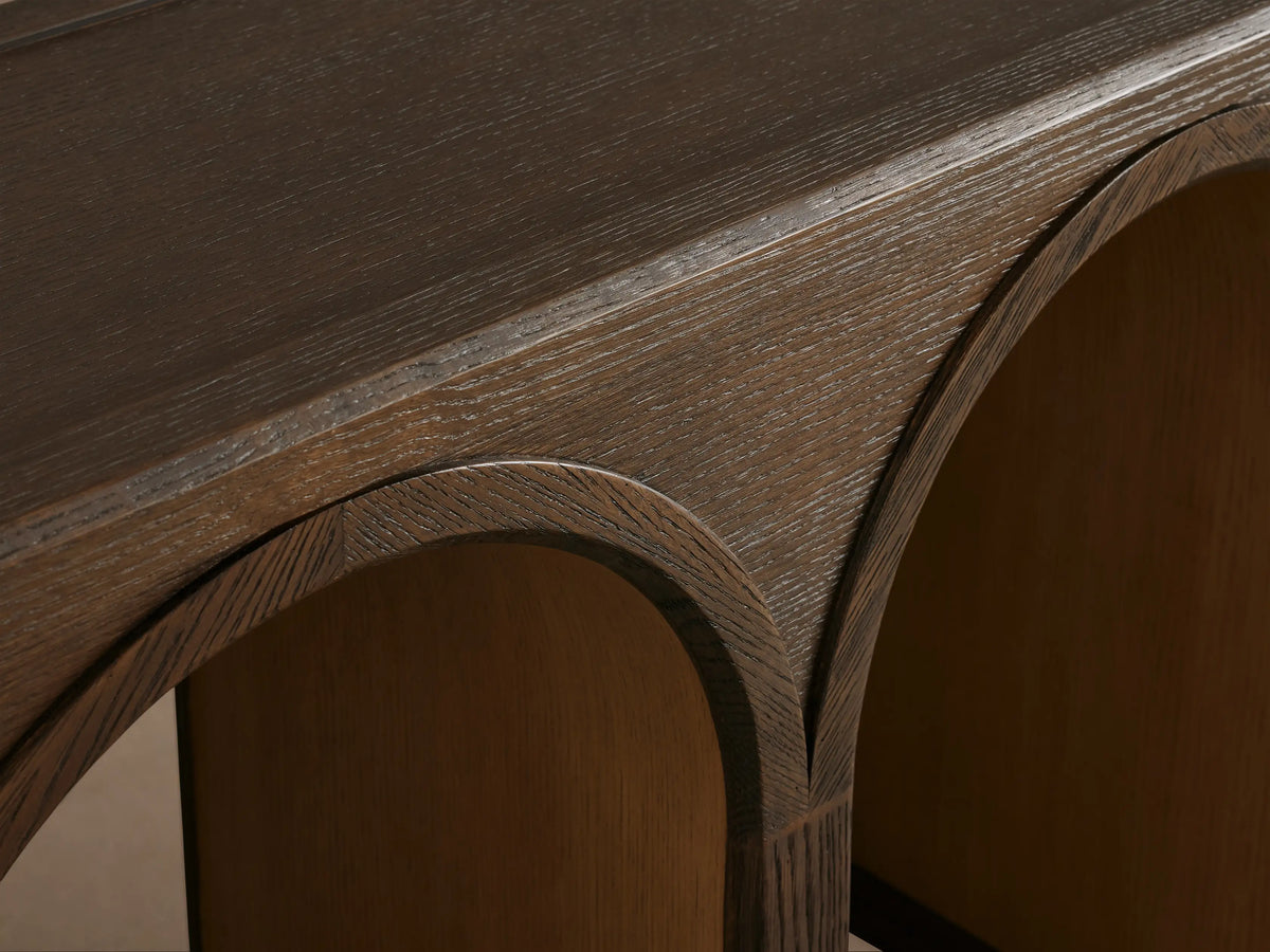 Hattie Console Table made of solid oak wood, features arched legs with contrasting interiors against a neutral background.