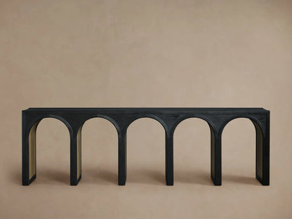 Hattie Console Table with black oak top, arched design, and contrasting interior finish on a beige background.