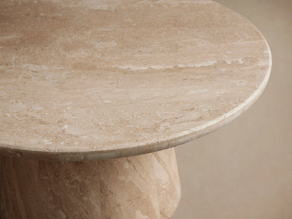 Hemmings Stone Nesting Coffee Table, round light beige stone with natural veining and a tapered base, on a wooden floor.