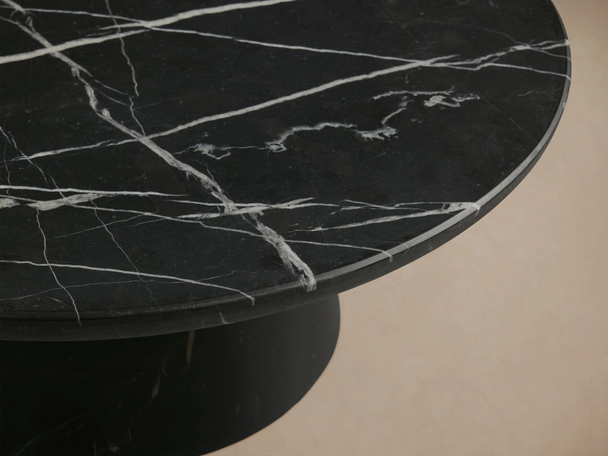 Hemmings Stone Nesting Coffee Table with a round black marquina marble top featuring white veining on a conical black base.