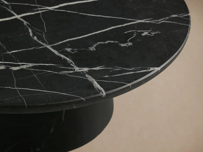 Hemmings Stone Nesting Coffee Table with a round black marquina marble top featuring white veining on a conical black base.