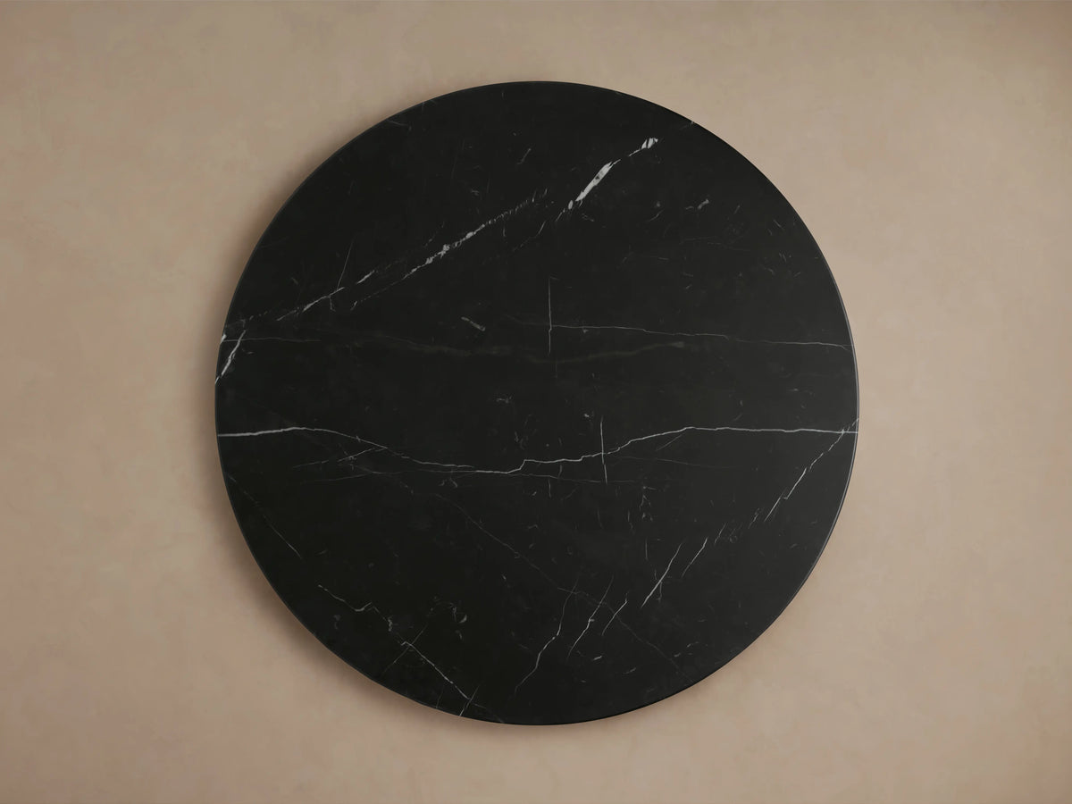 Close-up of the Hemmings Stone Nesting Coffee Table, featuring a round black marquina marble top with white veining patterns.