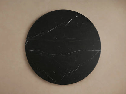 Close-up of the Hemmings Stone Nesting Coffee Table, featuring a round black marquina marble top with white veining patterns.