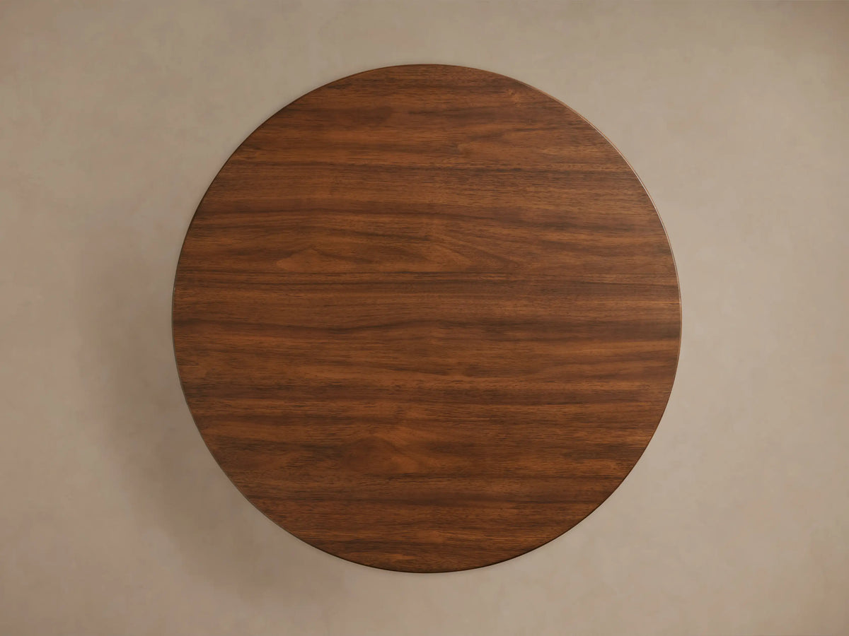 Close-up of Hemmings Nesting Coffee Table, showing round top and cylindrical base with rich brown walnut wood grain.