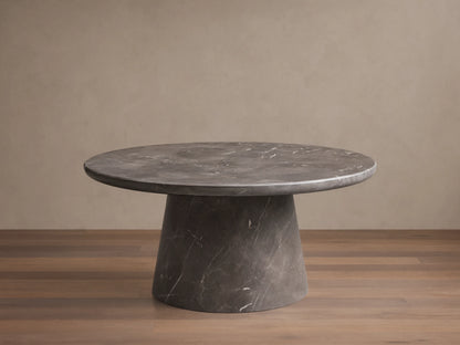 Front view of a dark gray round marble coffee table with prominent white veining, featuring a thick round top and a conical base.