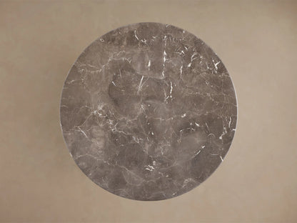 Close-up of the round dark grey marble table top with white veining.