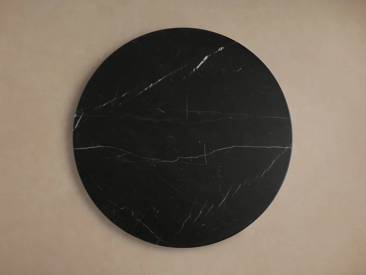 Black marquina marble tabletop of the Hemmings Stone Nesting Coffee Table with white veining patterns on a round surface.