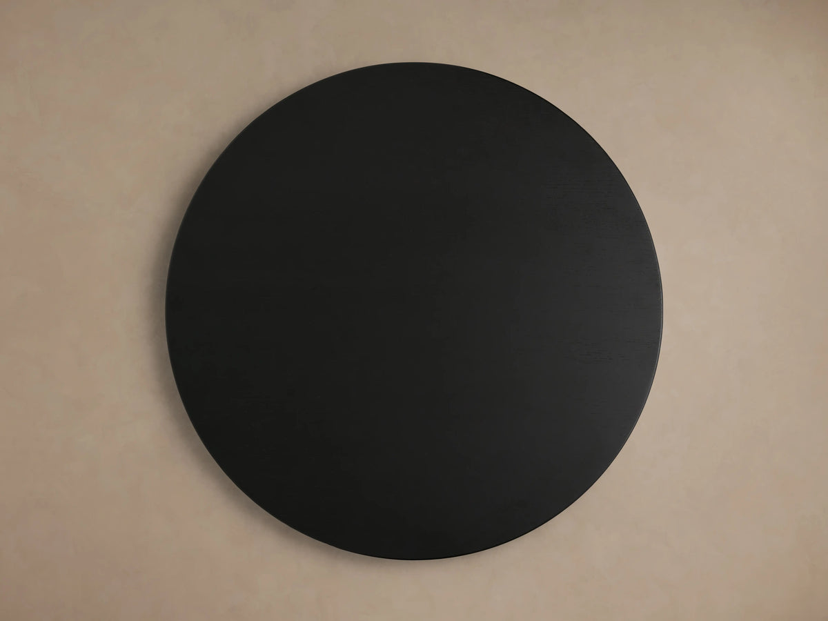 Circular tabletop of the Hemmings Nesting Coffee Table in black oak wood veneer finish, against a beige background.