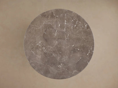 Top-down view of a circular gray marble surface with white veining.