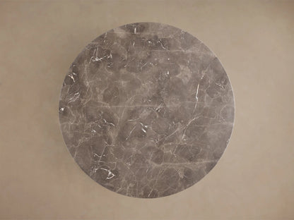 Front view of a round dark gray marble dining table with a thick pedestal base and white veining.