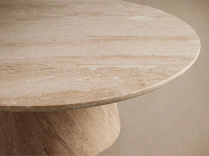 Close-up of Hemmings Stone Nesting Coffee Table. Round beige marble top with natural veining and matching round base.