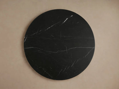 Close-up of Hemmings Stone Nesting Coffee Table. Round black marquina marble top with white veining on a black marble base.