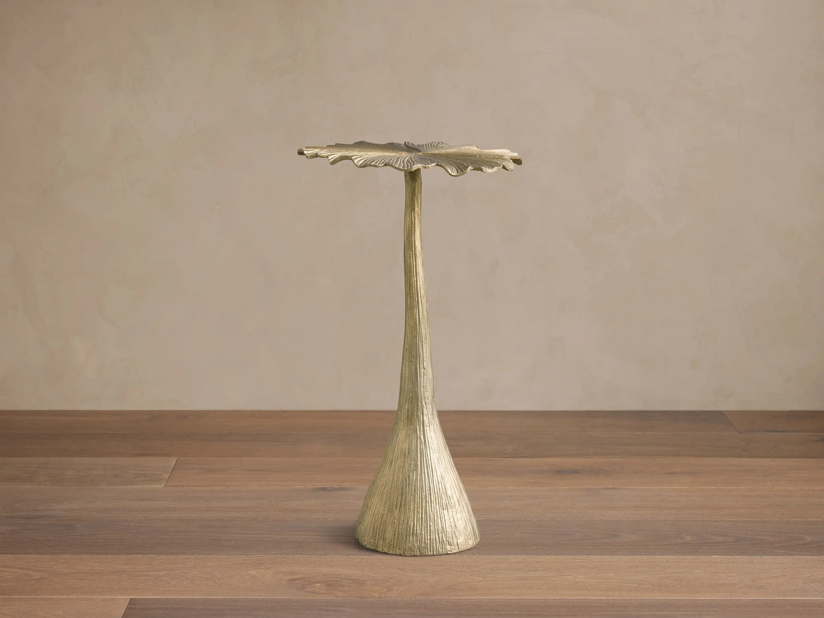 Front view of the Gold Abalone Shell Accent Table with a wavy, shell-shaped top and a slender, textured base.