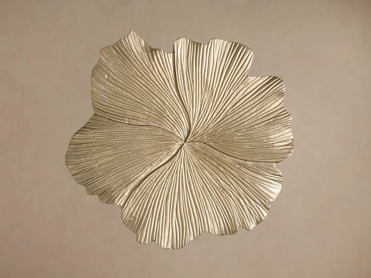 Top view of a gold metallic leaf-shaped decorative object with prominent, intricate radial veins and a textured surface.