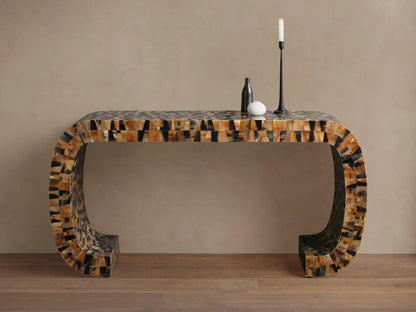 Lindly Console Table with rounded U-shape, intricate mosaic of natural brown, black, amber horn pieces. On a wooden floor.