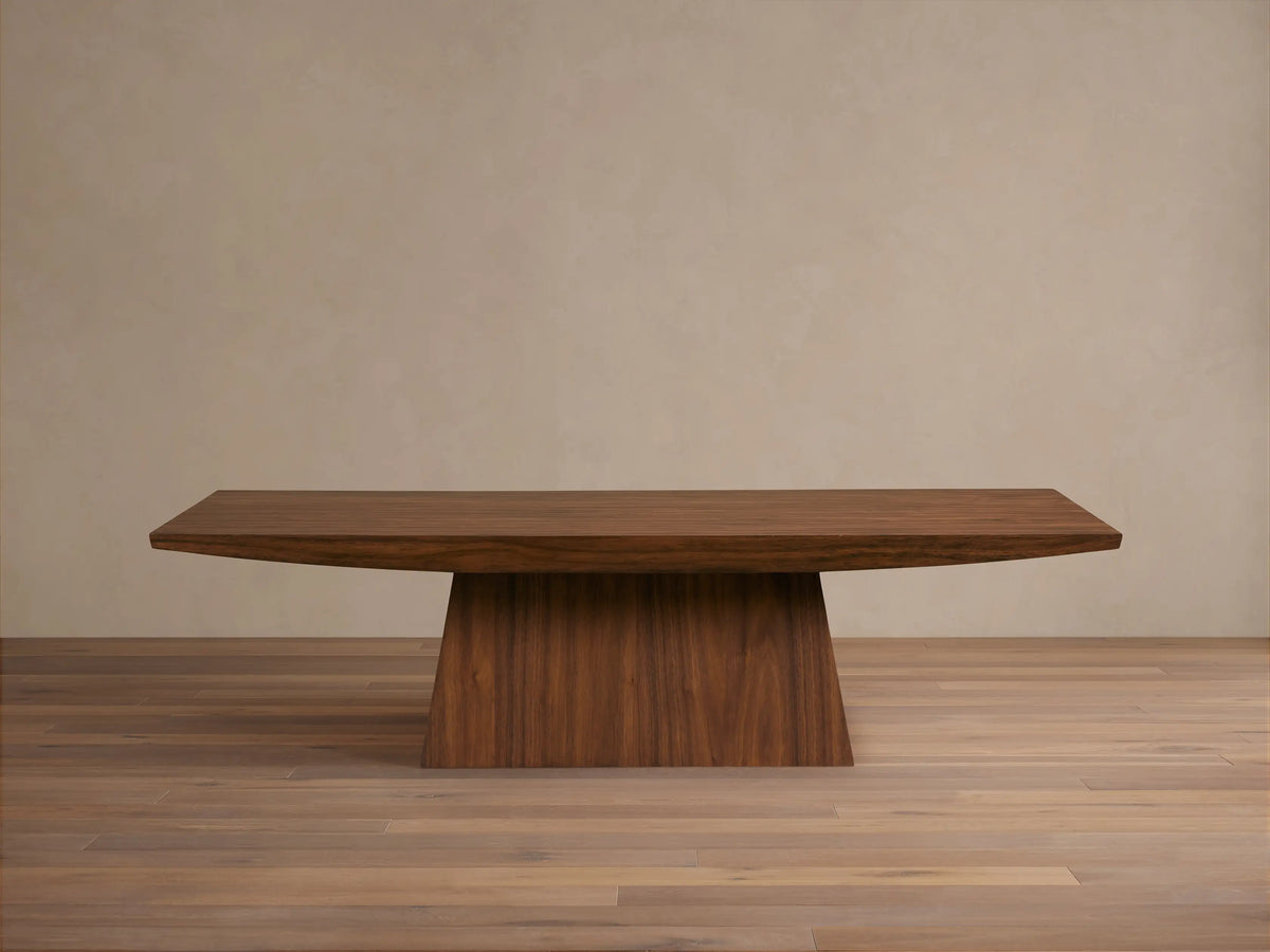 Ilaria Coffee Table with a rectangular walnut finish, featuring a wide, flat surface and tapered, sturdy base on wooden floor.
