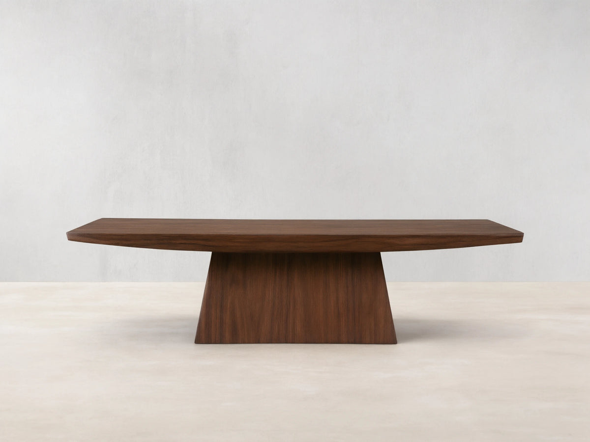 Ilaria Coffee Table with a rectangular walnut finish, featuring a wide, flat surface and tapered, sturdy base on wooden floor.