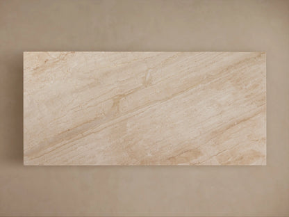 Beige marble table with a rectangular top and a geometric, trapezoidal base. The surface features subtle veining patterns.