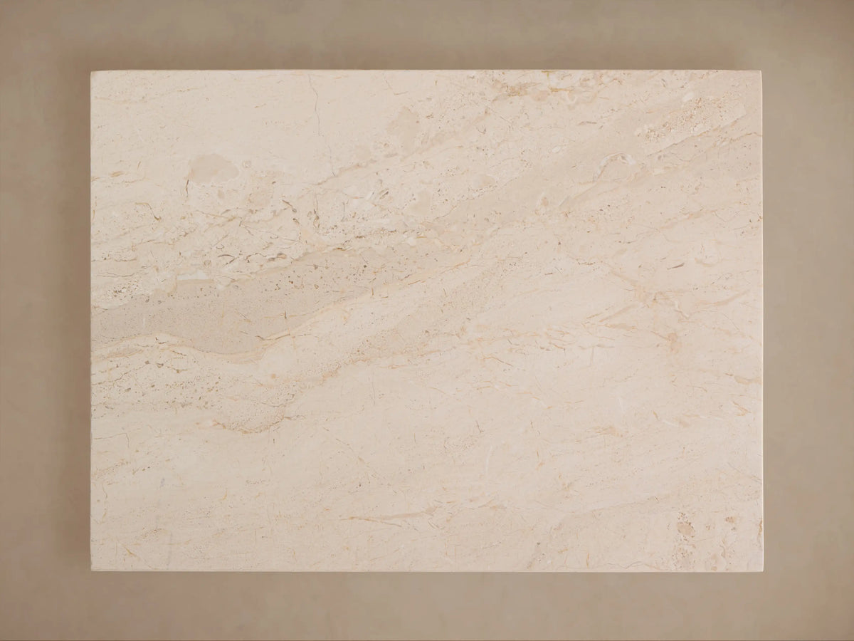 Stone table with a rectangular top and tapered base in beige tones, featuring a smooth, textured surface and subtle natural patterns.