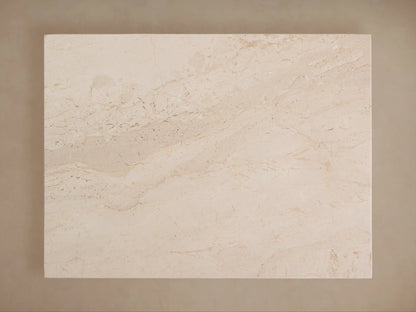 Stone table with a rectangular top and tapered base in beige tones, featuring a smooth, textured surface and subtle natural patterns.