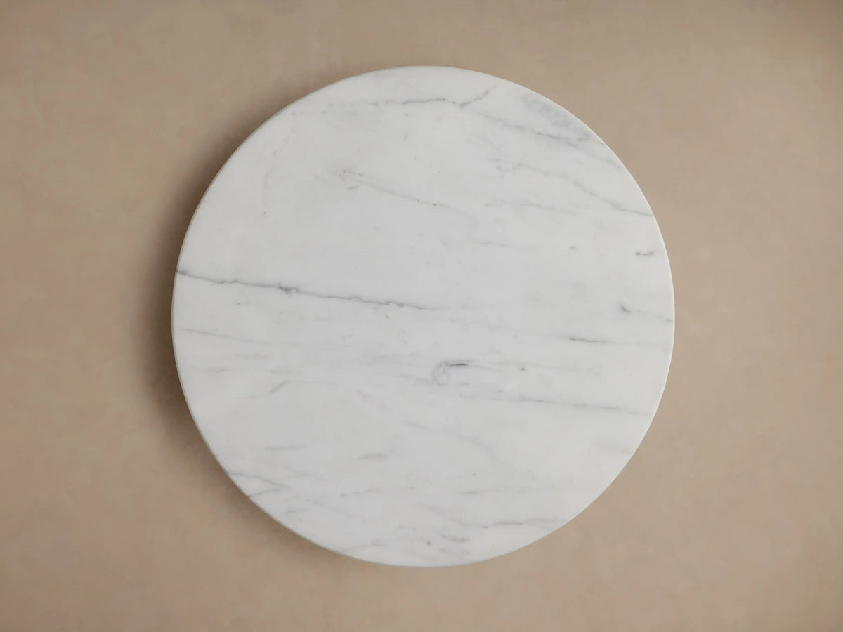Marble-topped Jorah Martini Table with a round white surface; gold base visible below, close-up angle.